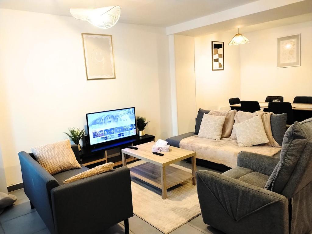 a living room with a couch and a tv at Ô Bon Goût in Bourges