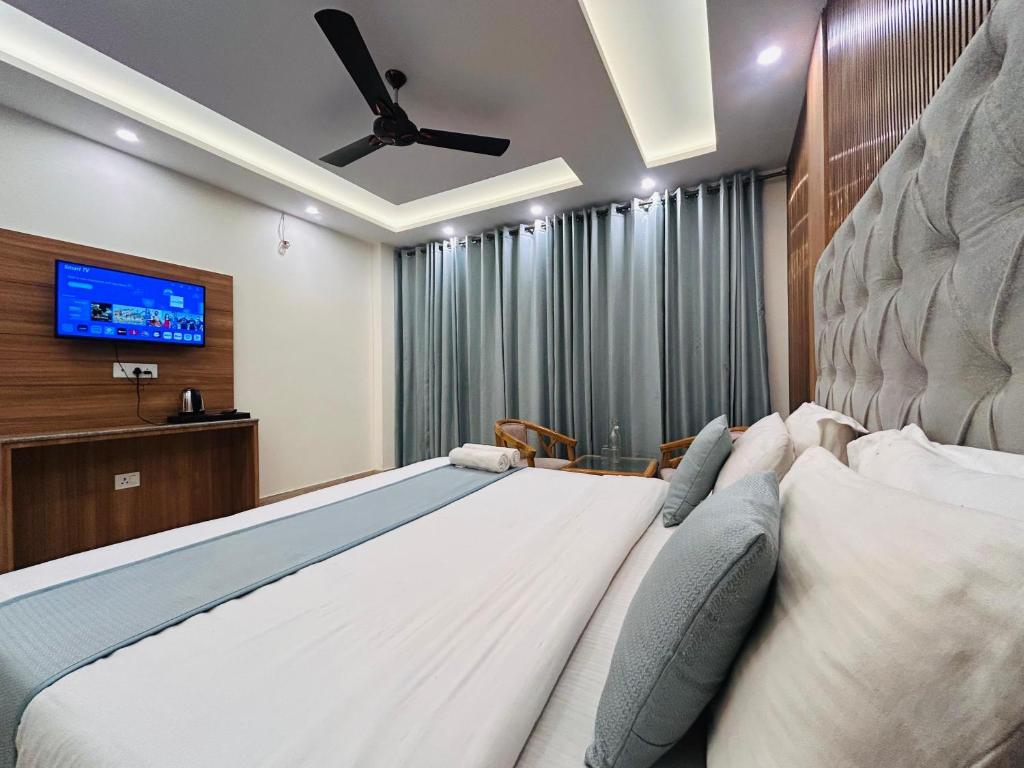 a bedroom with a large bed and a flat screen tv at Oakleaf Hotel & Resort - A Classic Rooms & Prime Location Near Library Chowk in Mussoorie