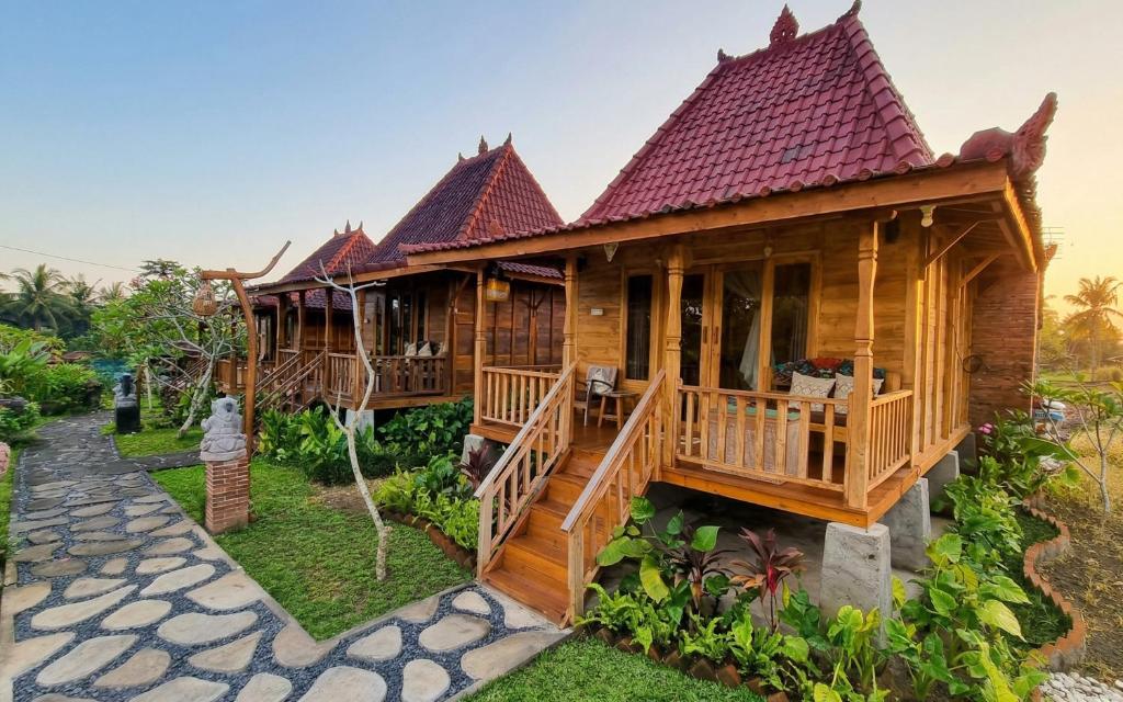 a wooden house with a porch and a deck at Sirya Farm House in Meliling