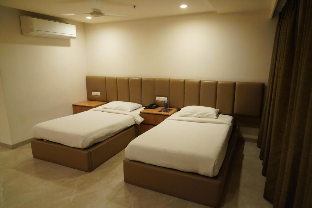 a room with two beds in a room at Hotel Shubham Prestige in Surūrnagar