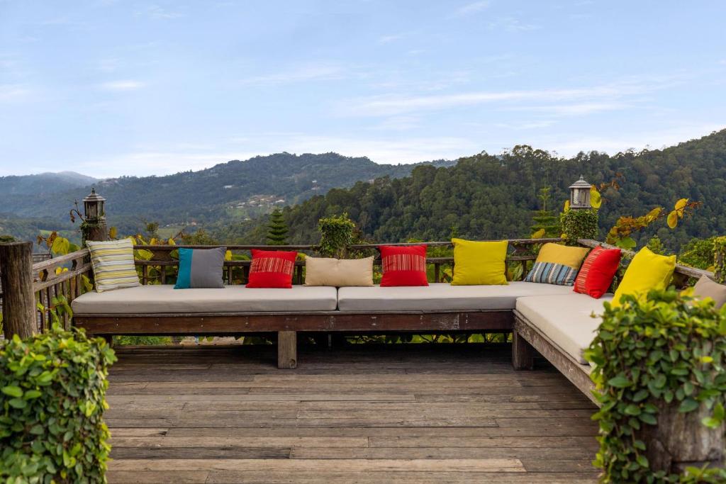 a bench with colorful pillows sitting on a deck at Baan Mon Muan in Mon Jam