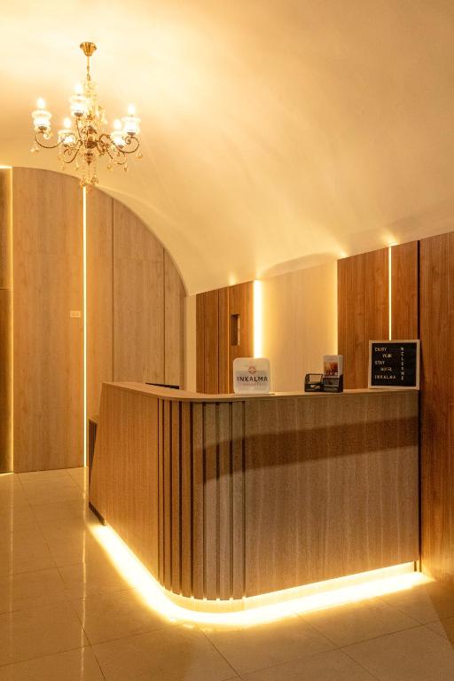 a lobby with a reception desk and a chandelier at Hotel Inkalma Santa Marta in Arequipa