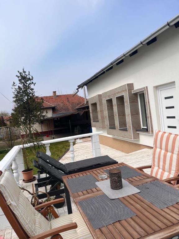 a deck with a table and chairs on a balcony at Ladislaus Garden Suites in Cegléd