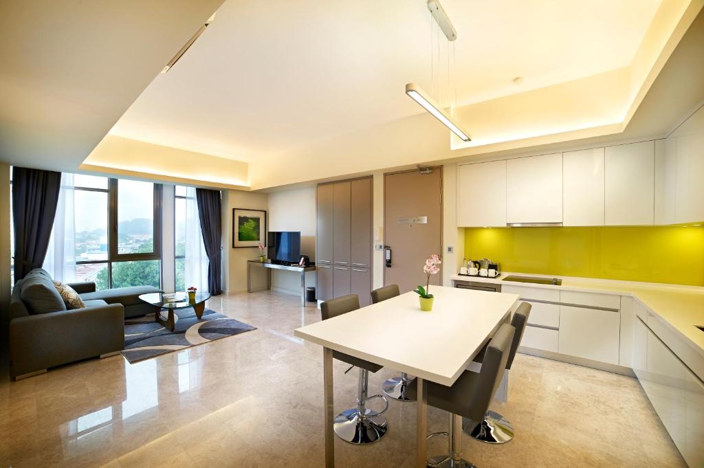 An open-plan suite with a full kitchen, dining table and separate living area.