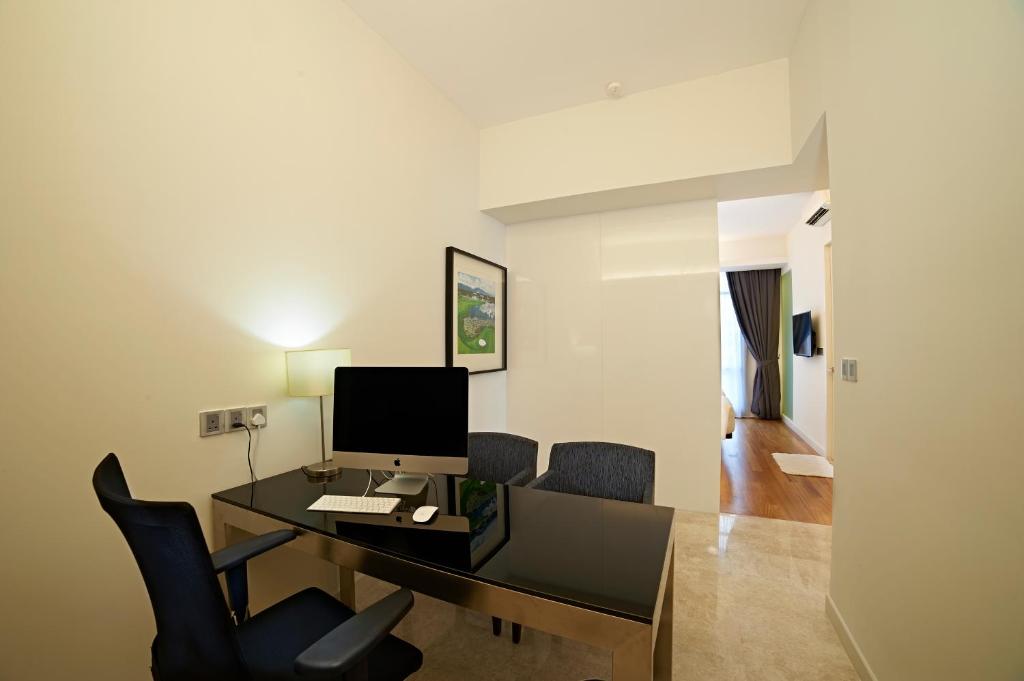 A private work area with a desktop computer, broad desk and two visitor chairs.