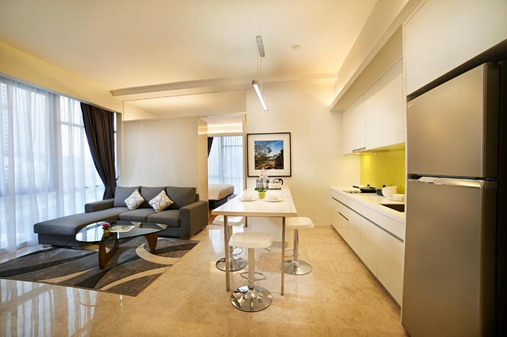 An open-plan suite with a kitchen island, lounge, and bright corner windows.