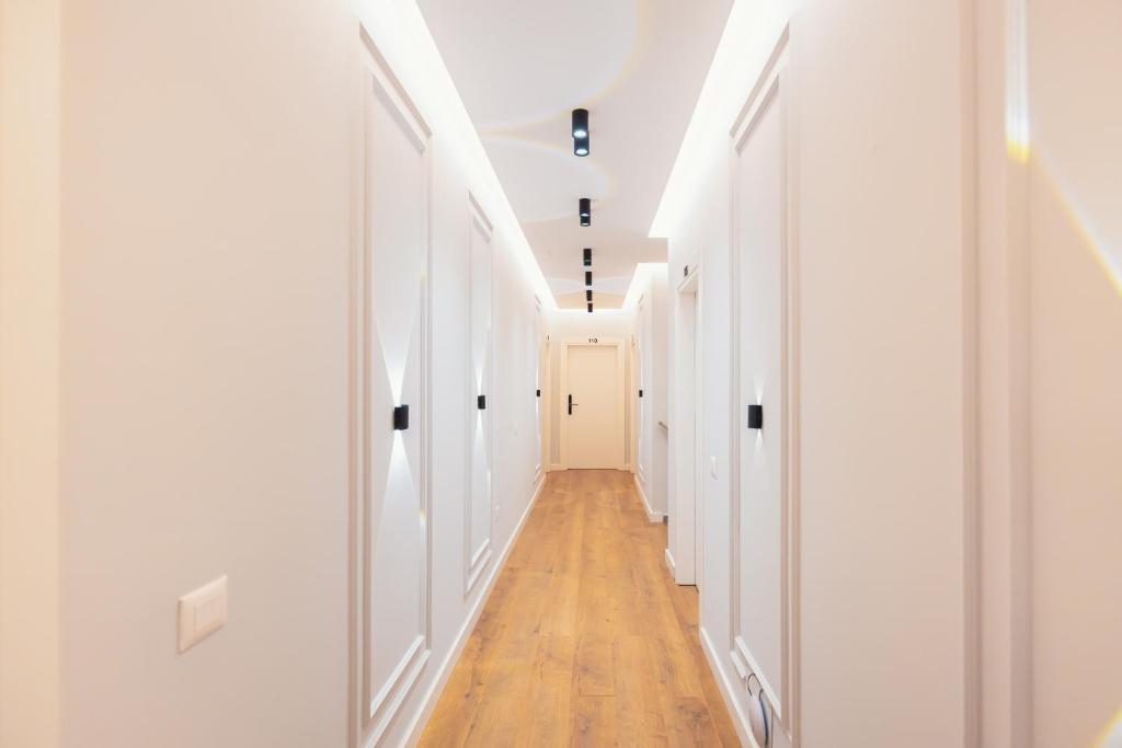 a hallway with white walls and a wooden floor at Hotel Relax City Center in Tirana