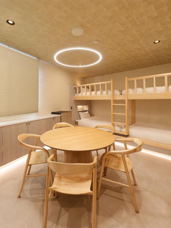 a room with a table and chairs and bunk beds at HAKORU Tokyo 八炬ル in Tokyo