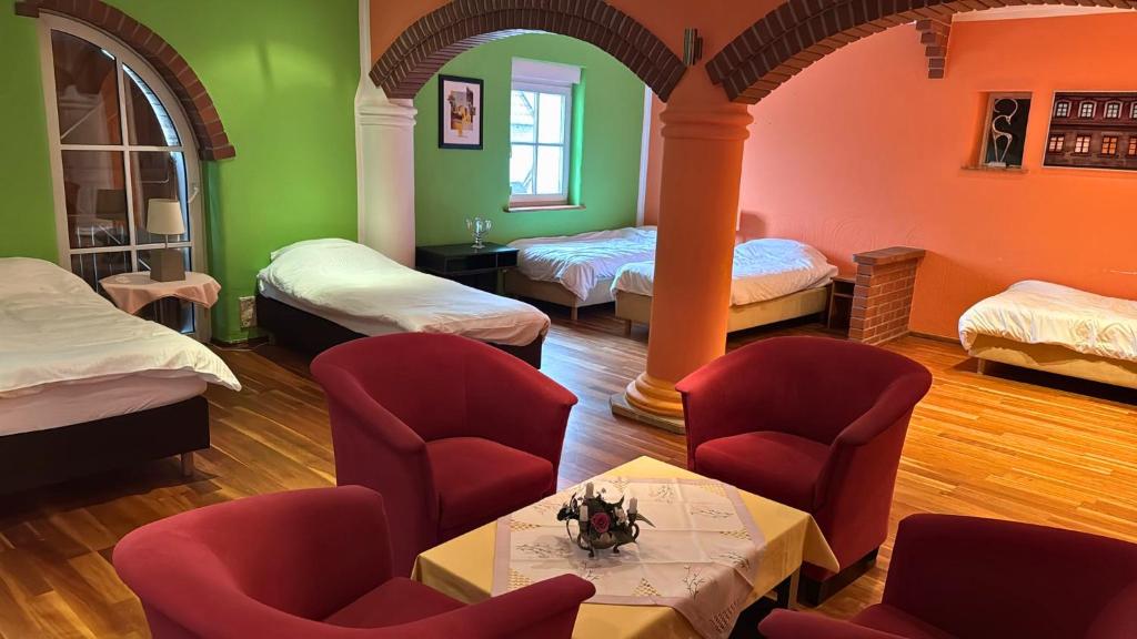 a room with four beds and chairs and a table at Hotel Relax in Wachenroth