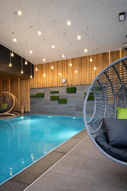 a swimming pool with a wicker chair next to it at Villa Silva - Oberhof in Oberhof