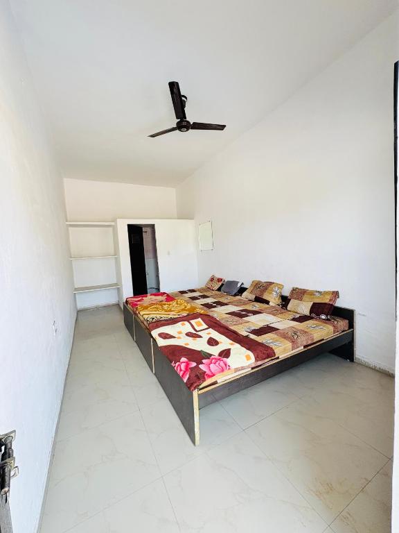 a bed in a room with a ceiling fan at Shivraj guest house in Ābu Road