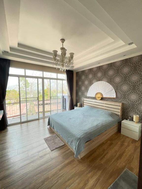 a bedroom with a bed and a large window at Dans den in Pai