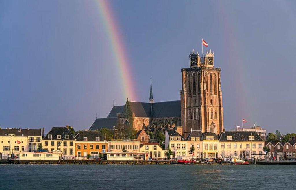 a rainbow over a large building with a clock tower at Loft appartement centrum Dordrecht nieuw 2026 in Dordrecht
