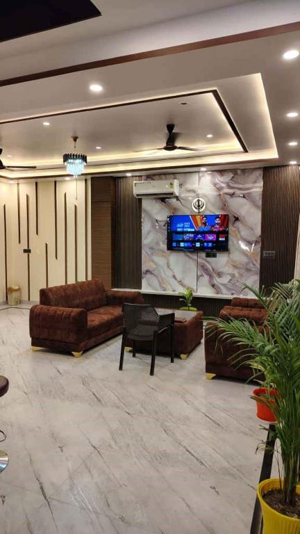 a living room with couches and a large stone wall at prabh aasra in Ayodhya