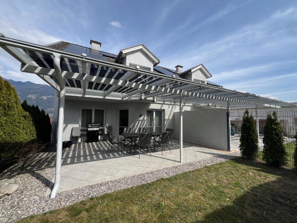 a white pergola on a patio in front of a house at Haus Lurnfeld in Baldramsdorf