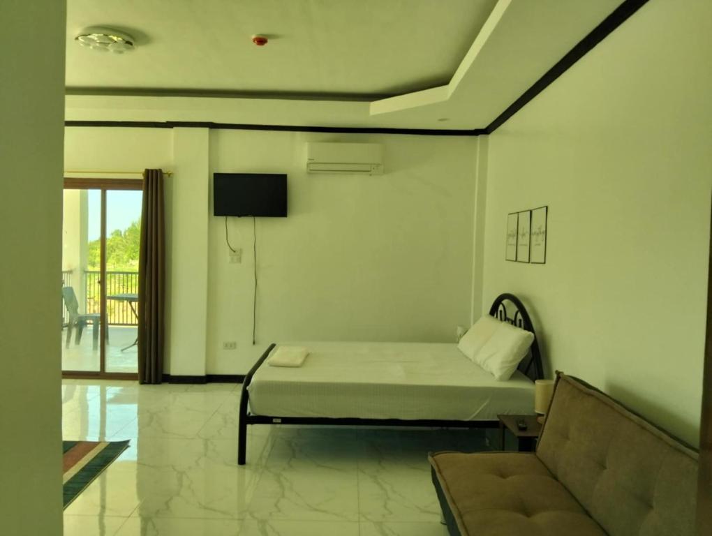 a living room with a bed and a couch at Safe Haven Residence in Talibon