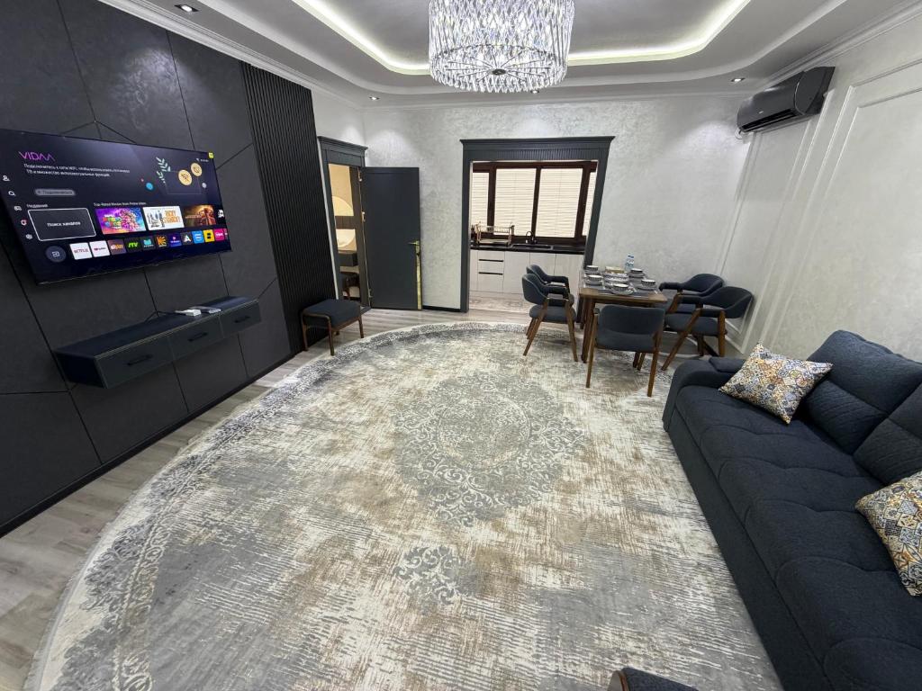 a living room with a couch and a tv and a table at Guest house Пары Резиденты только с ЗАГСом in Samarkand