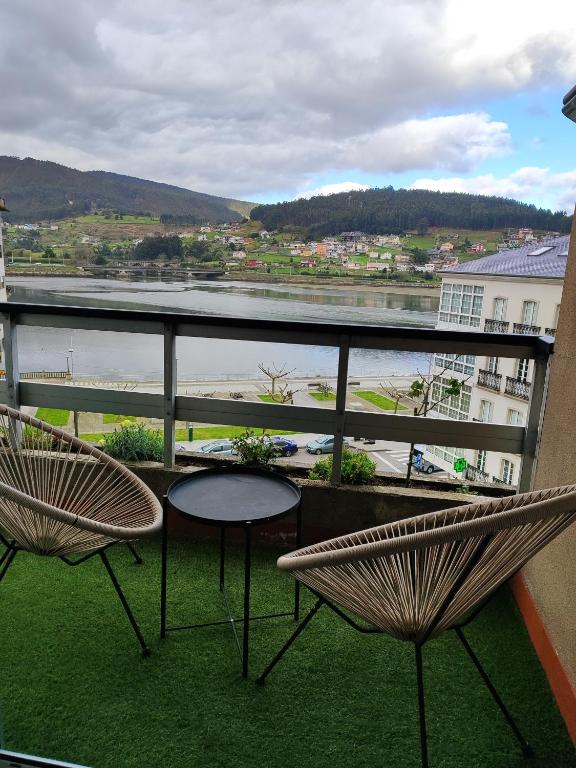 a balcony with two chairs and a table at Piso en el centro de Viveiro in Viveiro