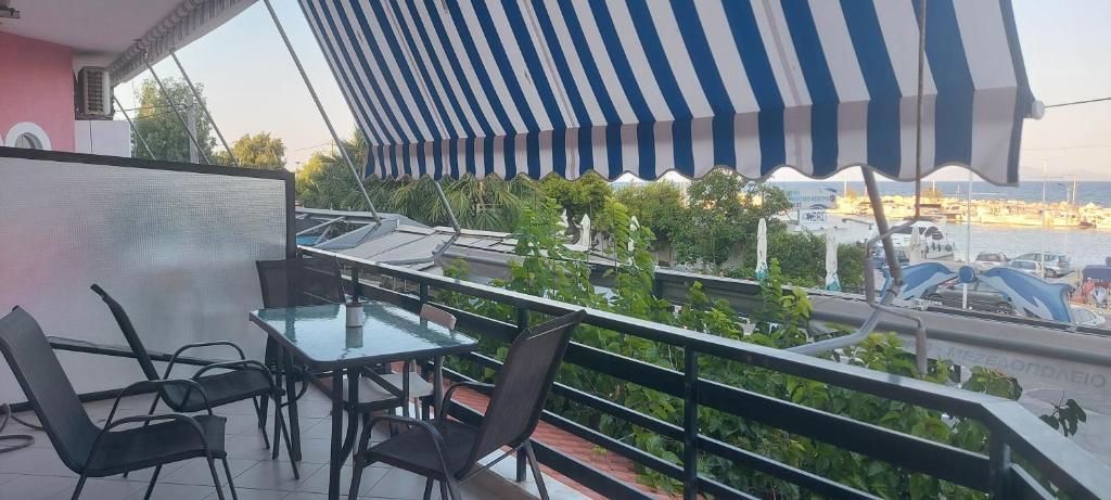 a balcony with a table and chairs and a view of the water at Sunrise story in Artemida