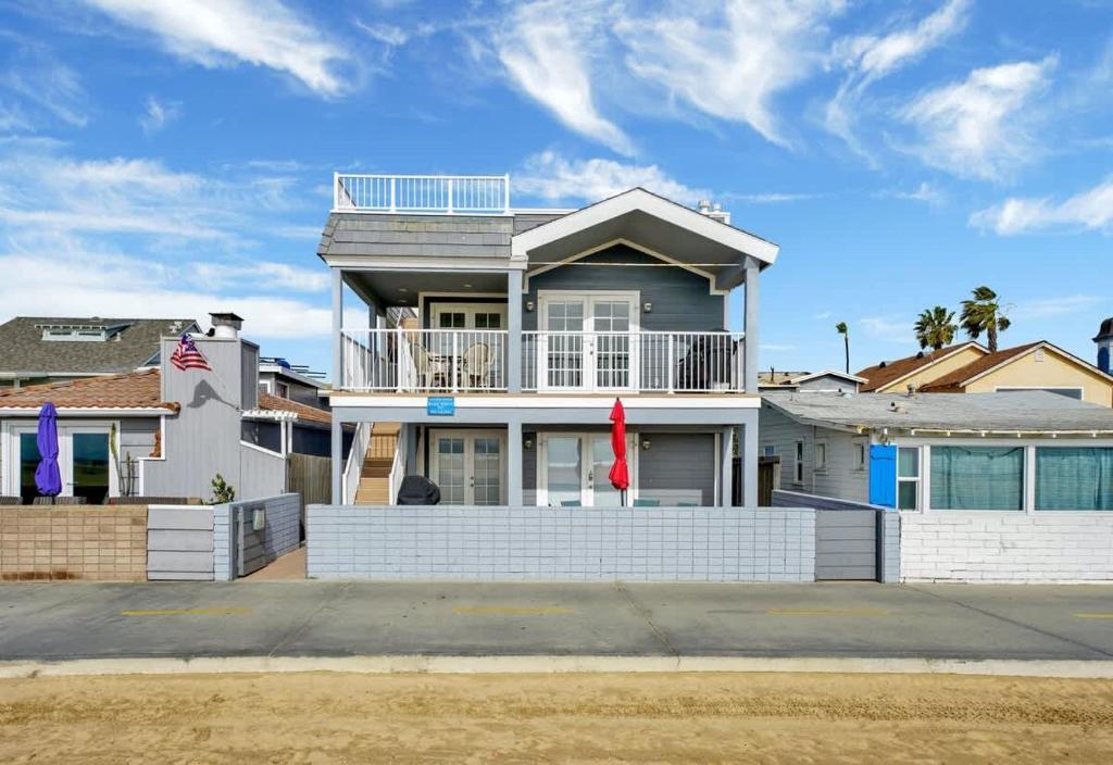 a large white house with a balcony on a street at Value Beachfront withLarge Patio On The Bike Path apts in Newport Beach