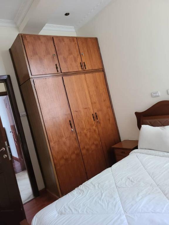 a bedroom with a large wooden cabinet next to a bed at Aster Mekuria in Addis Ababa