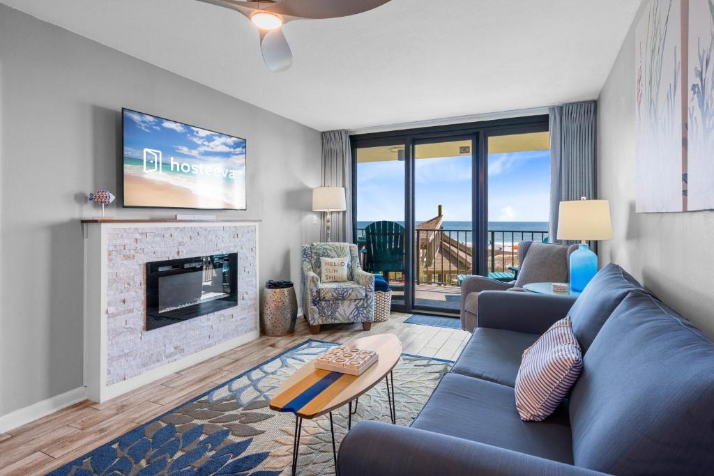 a living room with a blue couch and a fireplace at Phoenix II 2012 in Orange Beach