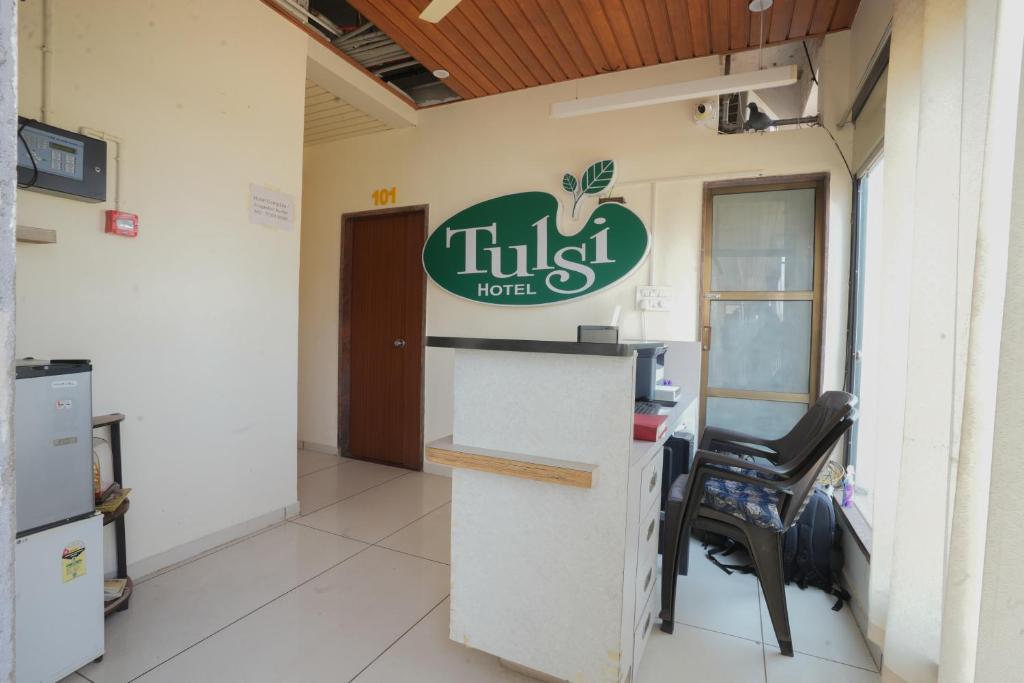 a lobby of a hotel with a desk and a chair at Hotel Tulsi in Nadiād