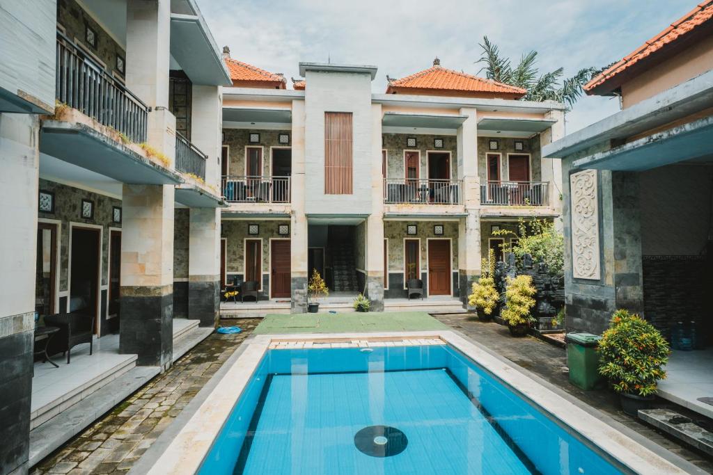an exterior view of a house with a swimming pool at Santhi Graha Guest House in Legian
