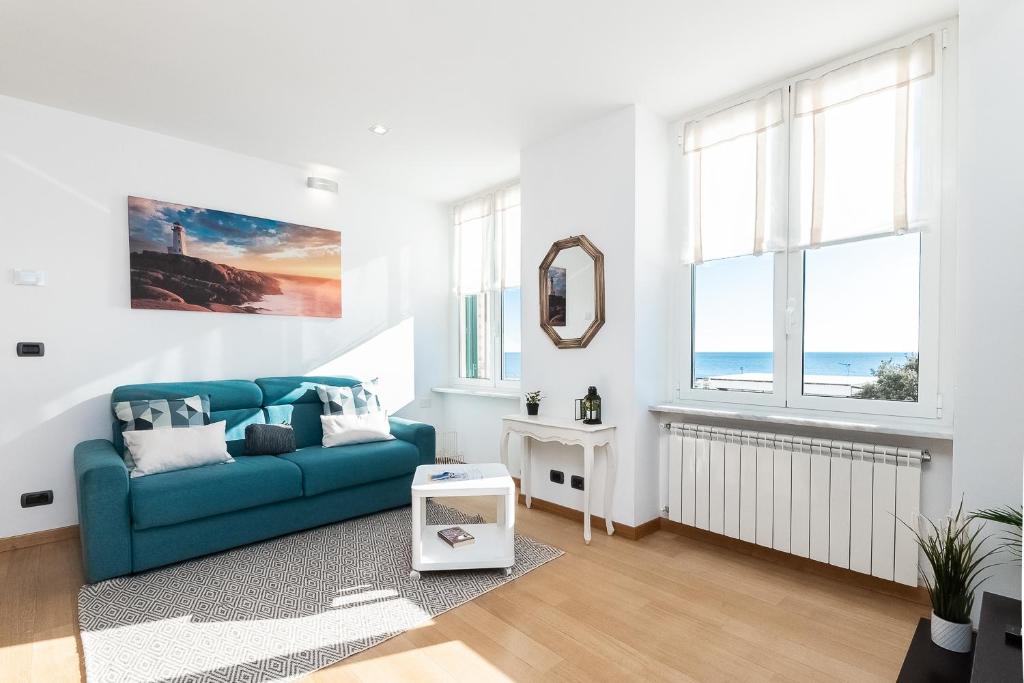 a living room with a blue couch and windows at -Fronte Mare- Centro Storico in Varazze