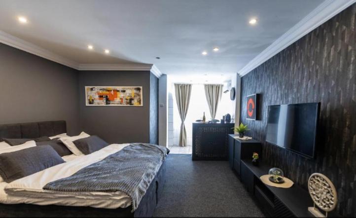 a bedroom with a large bed and a flat screen tv at Royal 2 in Bucharest