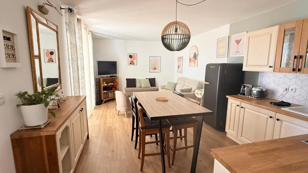 a kitchen and living room with a table and a dining room at Appartement golf saumane Celomidie in Saumane-de-Vaucluse