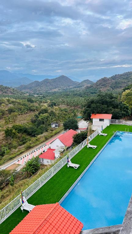 an aerial view of a large swimming pool with chairs at Mountain Breeze Neyyans in Attappādi