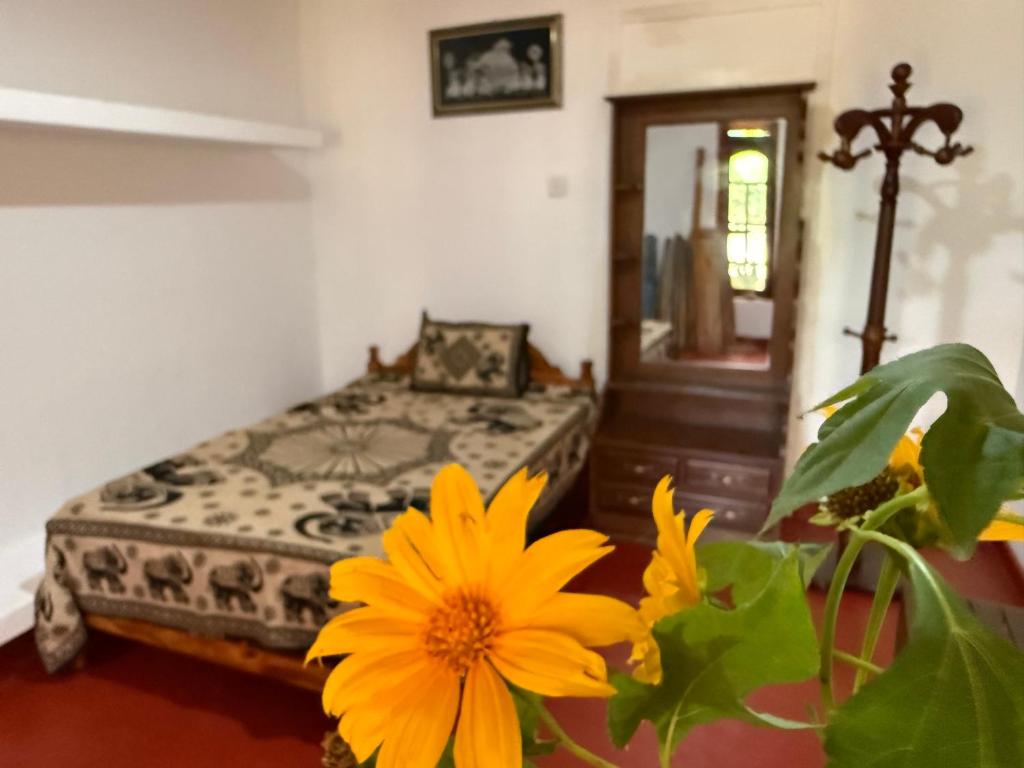 a bedroom with a bed and a yellow flower at Beliya Rock View in Dambulla