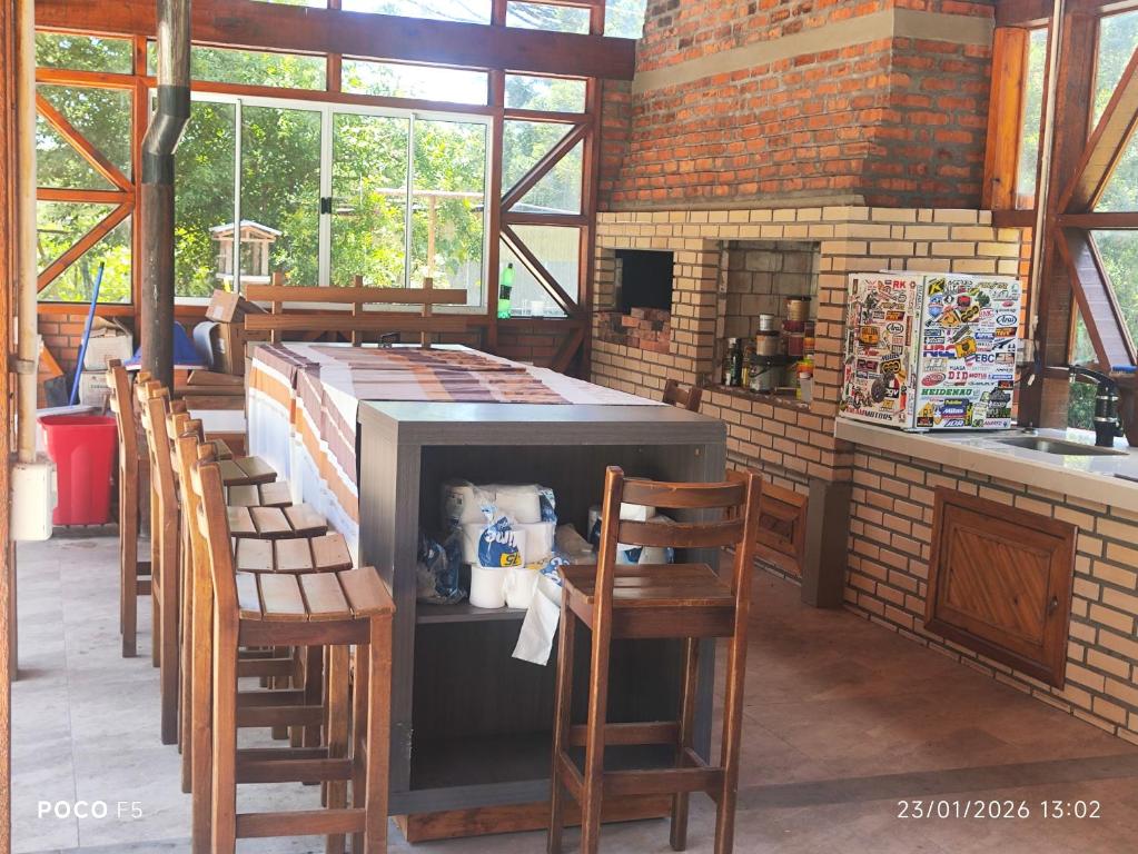 a restaurant with a counter and chairs in a room at Posada Das Araucárias in Caxias do Sul