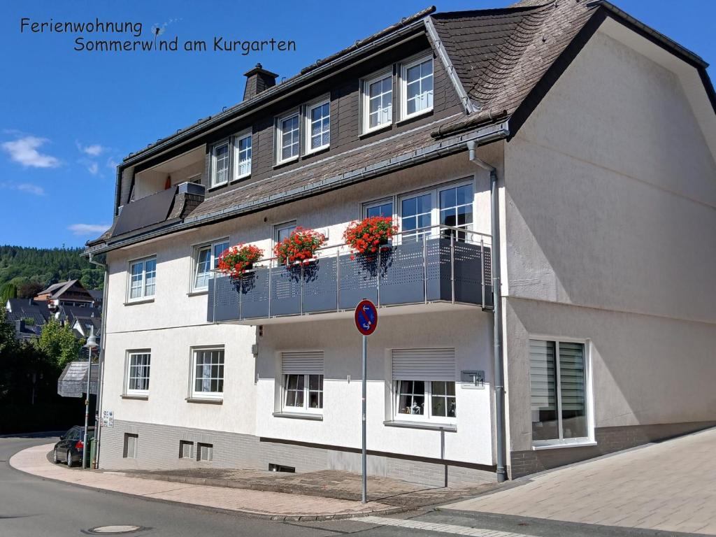 a white building with flower boxes on the windows at Sommerwind am Kurgarten in Willingen