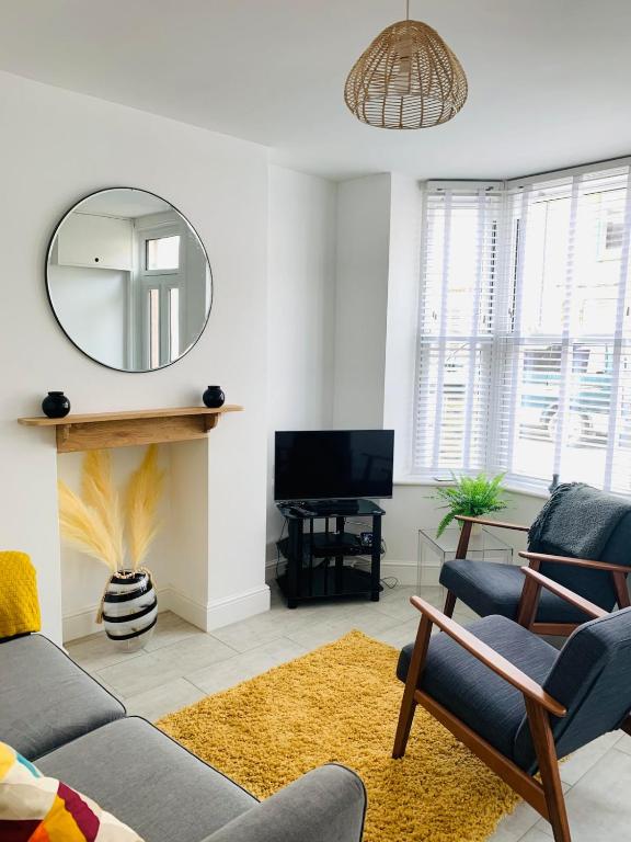 a living room with a couch and a mirror at Number 15 in Whitstable