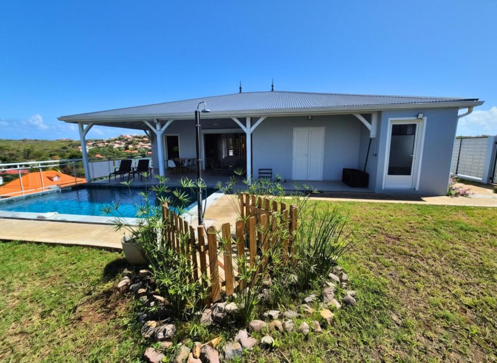 a house with a swimming pool in a yard at Villa Gommier - 3 chambres, 3 sdb, piscine in Le Diamant
