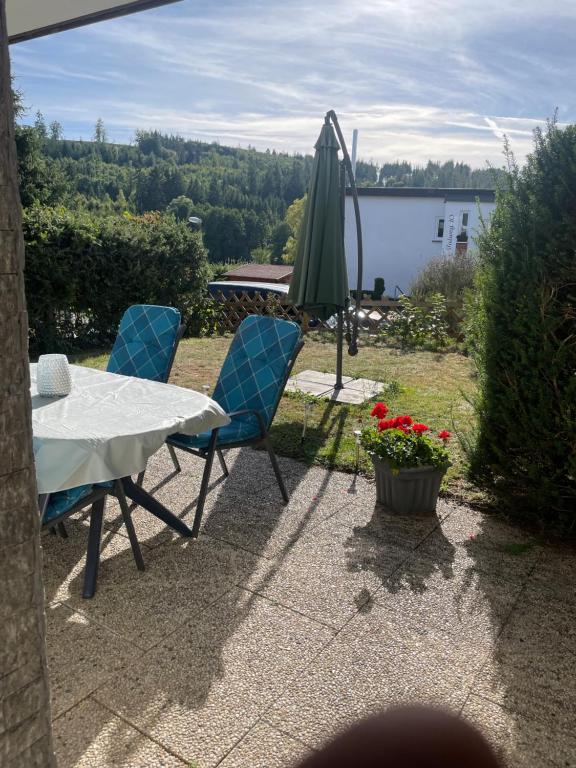 a table and chairs and an umbrella on a patio at Bungalow Orketal Sauerland in Medebach