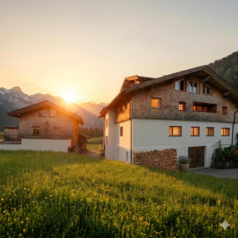 a house on a hill with the sunset in the background at Braito's Seaside Lodges und Suites, Ferienhäuser und Ferienwohnungen in Haldensee