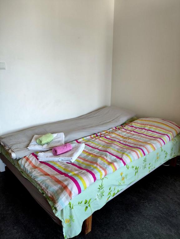 a bed with a colorful comforter and towels on it at Sun life room in Stockholm