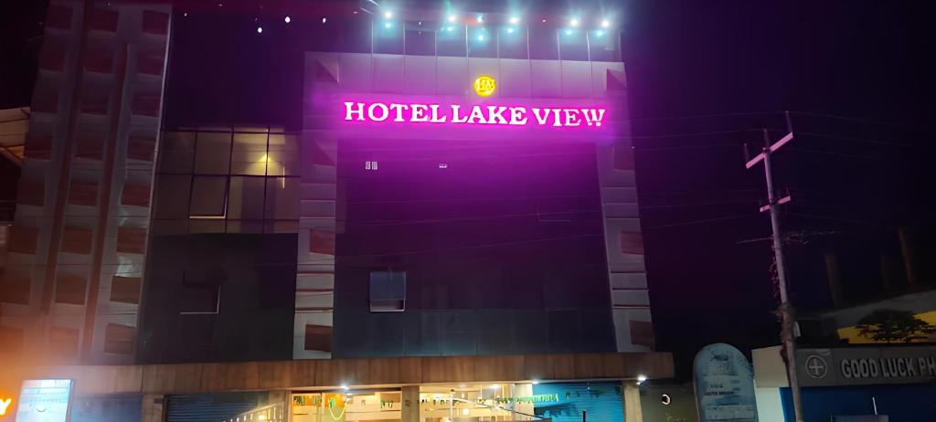 a building with a neon sign on it at night at Hotel Lake View in Port Blair
