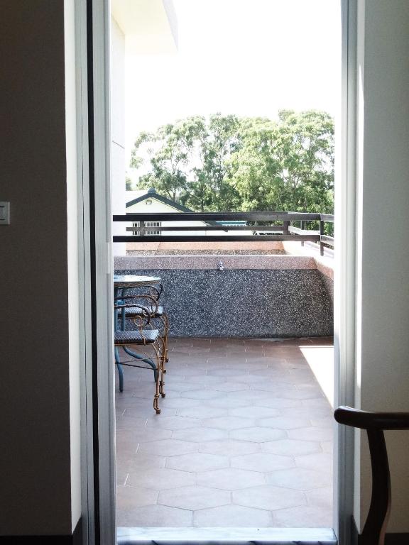 an open door to a balcony with a table and chairs at Ikegami Dapo Moutain Bed and Breakfast in Chishang
