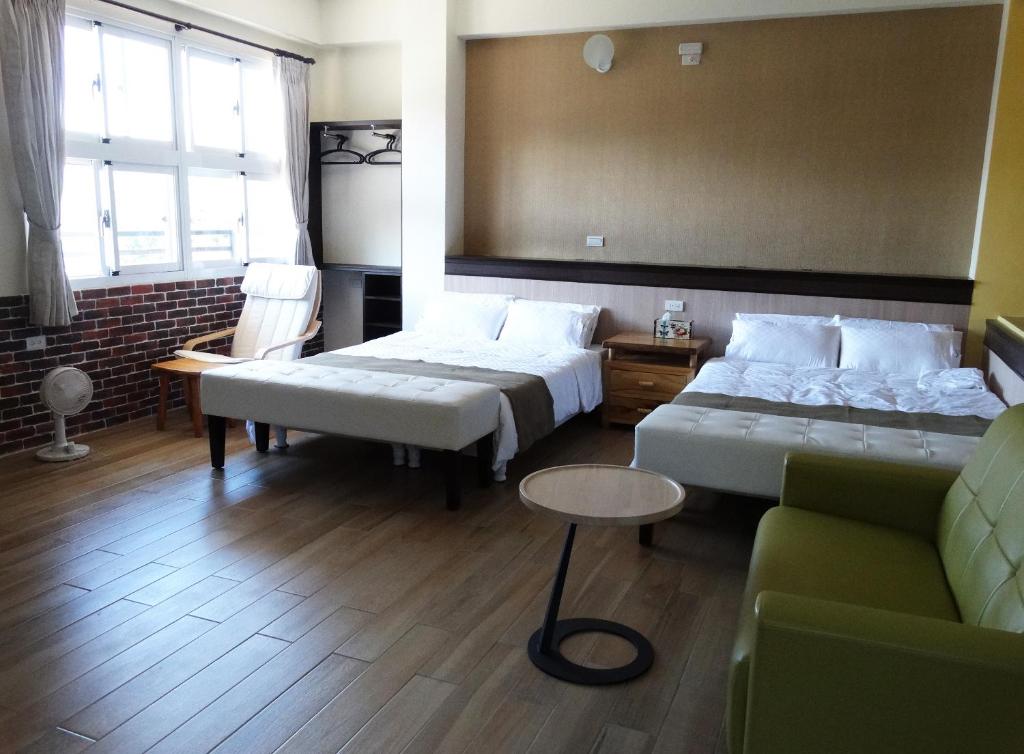 a hotel room with two beds and a couch at Ikegami Dapo Moutain Bed and Breakfast in Chishang