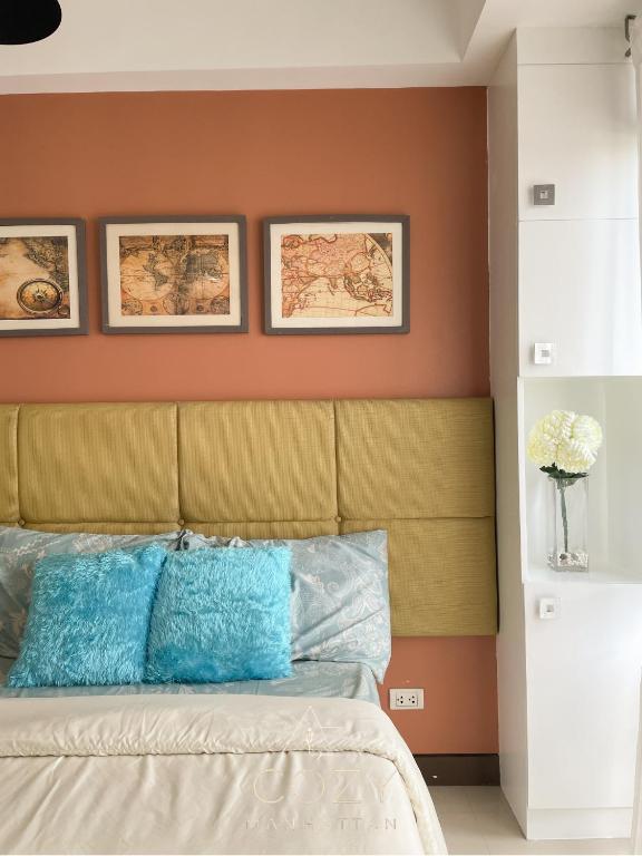 a bedroom with a bed with three pictures on the wall at Studio Unit in Manhattan Heights with Balcony in Sampong