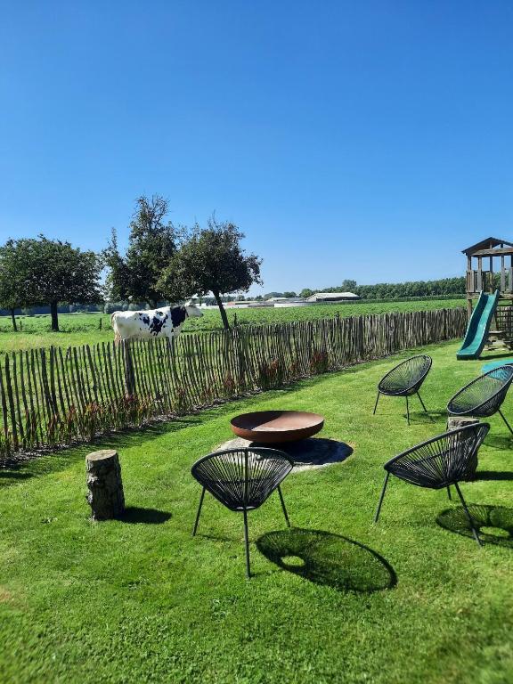 a group of chairs and tables in the grass at Hof ter Eversam in Alveringem