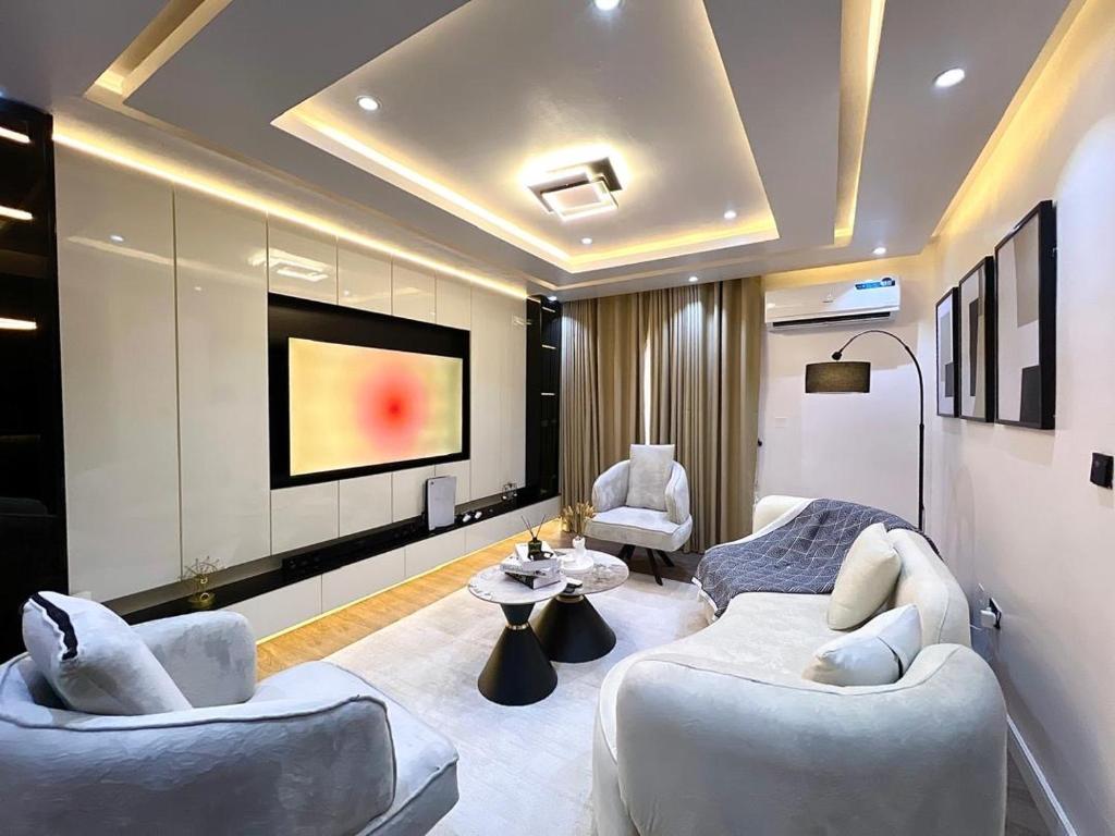 a living room with two couches and a flat screen tv at NEW! 2BDR Maisonette with PS5 and balcony in Lekki phase one in Lekki