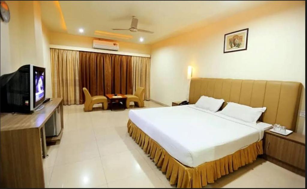 a hotel room with a bed and a television at Hotel Sitara Grand, KPHB in Hyderabad