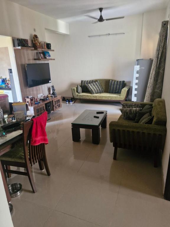 a living room with two couches and a coffee table at Anwesha's Home Stay Alibaug in Alibaug