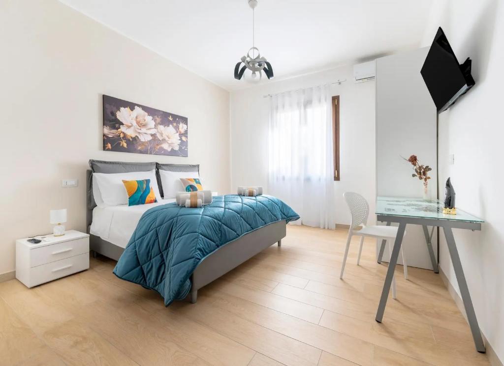 a white bedroom with a bed and a desk at Quintessenza- Luxury Suites in Leverano