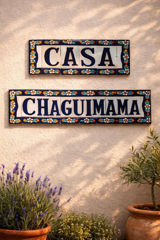 a sign on the side of a building with plants at CASA CHAGUIMAMA Begur in Begur